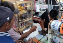 TUKAR. Wahed (46), seorang abang becak, menukarkan kupon takjil dari PWRI Sumenep kepada pedagang di kawasan Tajamara, Sumenep, untuk mendapatkan menu berbuka puasa saat Ramadan. (redaksi/estoria)