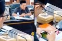 Anggota DPRD Jember terlihat memainkan game di ponselnya sambil memegang rokok saat Rapat Dengar Pendapat (RDP) Komisi D yang membahas layanan kesehatan, momen yang kemudian viral dan menuai sorotan publik. (Sumber Foto: Istimewa)