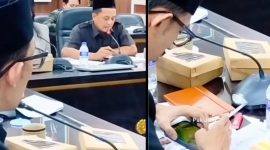 Anggota DPRD Jember terlihat memainkan game di ponselnya sambil memegang rokok saat Rapat Dengar Pendapat (RDP) Komisi D yang membahas layanan kesehatan, momen yang kemudian viral dan menuai sorotan publik. (Sumber Foto: Istimewa)